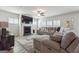 Comfortable living room showcasing a fireplace, large television, cozy sectional, and bright windows with plantation shutters at 6910 Newcastle Ct, Fairburn, GA 30213