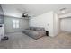 Spacious living room with a large gray couch, neutral carpet, and ample natural light at 6910 Newcastle Ct, Fairburn, GA 30213