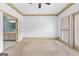 Spacious bedroom with carpeted floors, a ceiling fan, and two doors to the bathroom at 180 Habersham Pl, Fayetteville, GA 30214
