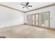 A bedroom featuring a ceiling fan, carpeted floors, and doors to the backyard at 180 Habersham Pl, Fayetteville, GA 30214