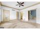Open view of a carpeted bedroom featuring a ceiling fan and two doors to the bathroom at 180 Habersham Pl, Fayetteville, GA 30214