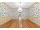 Charming dining room with a chandelier, floral wallpaper, and hardwood flooring throughout at 180 Habersham Pl, Fayetteville, GA 30214