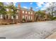 Street view showcasing the red brick townhouses with manicured front yards and mature trees at 180 Habersham Pl, Fayetteville, GA 30214