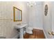 Traditional half bath with pedestal sink, gold fixtures, and decorative wallpaper at 180 Habersham Pl, Fayetteville, GA 30214