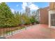 Spacious brick patio featuring black iron railing and lush green landscaping at 180 Habersham Pl, Fayetteville, GA 30214
