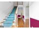 Bright and airy staircase with blue carpet, white risers, and elegant wood banister at 180 Habersham Pl, Fayetteville, GA 30214