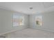 Bright bedroom with neutral carpet, two windows, and a simple ceiling light fixture at 560 Birkdale Dr, Fayetteville, GA 30215