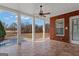 Covered patio with brick wall, ceiling fan, tile flooring, and a view of the fenced in pool at 560 Birkdale Dr, Fayetteville, GA 30215