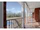 Covered brick patio overlooking fenced backyard, pool, and mature trees at 560 Birkdale Dr, Fayetteville, GA 30215