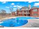 Large inground pool with multi-level brick home in background, all surrounded by a wrought iron fence at 560 Birkdale Dr, Fayetteville, GA 30215