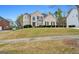 Charming brick home on a sloped lot, showcasing lush greenery and classic architectural details at 1536 Granby Ln, Locust Grove, GA 30248