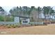 Stone monument sign marking the entrance to The Canoe Club, with lush landscaping at 545 Discovery Lake Dr # 409, Fayetteville, GA 30215