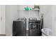Laundry room with side-by-side gray washer and dryer and storage shelf at 906 Sims Sw St, Atlanta, GA 30310