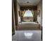 Spacious bathroom featuring a large soaking tub with tile surround and decorative window treatments at 5188 Ashley Se Dr, Covington, GA 30014
