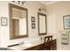 Bathroom vanity featuring double mirrors, wood cabinetry, and modern fixtures at 5188 Ashley Se Dr, Covington, GA 30014