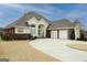 Beautiful home with brick accents, three-car garage, spacious driveway, and well-maintained lawn under a cloudy blue sky at 5188 Ashley Se Dr, Covington, GA 30014