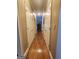 Long hallway with hardwood floors, beige walls, and white closet doors at 5188 Ashley Se Dr, Covington, GA 30014