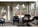 A sunroom with natural light, wicker chairs, and green-and-white curtains at 5188 Ashley Se Dr, Covington, GA 30014