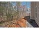 A charming view of the backyard featuring a small patio, decorative rocks and a wooded area at 204 Eleanor Ct, Stockbridge, GA 30281