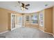 Sunlit bedroom with a ceiling fan, carpet, and French doors leading to another room at 204 Eleanor Ct, Stockbridge, GA 30281