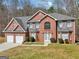 Charming two-story brick home with a two-car garage, manicured lawn, and beautiful landscaping at 204 Eleanor Ct, Stockbridge, GA 30281