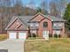 Charming two-story brick home with a two-car garage, manicured lawn, and beautiful landscaping at 204 Eleanor Ct, Stockbridge, GA 30281