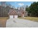Stunning two-story red brick home with a large driveway, attached garage and manicured front lawn at 204 Eleanor Ct, Stockbridge, GA 30281