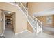 Bright foyer featuring a white staircase, tile flooring, and views into the kitchen and living spaces at 204 Eleanor Ct, Stockbridge, GA 30281