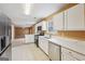 Kitchen with stainless steel appliances, white cabinets and view to the living room at 204 Eleanor Ct, Stockbridge, GA 30281