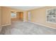 Spacious carpeted living room with multiple windows, plenty of natural light, and access to other rooms at 204 Eleanor Ct, Stockbridge, GA 30281
