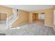 Spacious living room with neutral carpet, staircase, and access to dining area and kitchen at 204 Eleanor Ct, Stockbridge, GA 30281