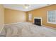 Cozy living room showcasing a classic fireplace, a ceiling fan, and natural light from adjacent windows at 204 Eleanor Ct, Stockbridge, GA 30281