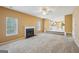 Bright and airy living room features a fireplace, ceiling fan, plush carpet, and view to the kitchen at 204 Eleanor Ct, Stockbridge, GA 30281