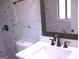 Updated bathroom with dark plumbing fixtures, a white vanity and a marble countertop at 5017 Galbraith Cir, Stone Mountain, GA 30088