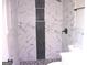 Modern bathroom featuring stunning marble-look tiling, a sleek black showerhead, and a convenient built-in niche at 5017 Galbraith Cir, Stone Mountain, GA 30088