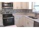 Close-up of kitchen featuring stainless steel appliances, modern backsplash, and stone countertops at 5017 Galbraith Cir, Stone Mountain, GA 30088