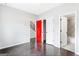 A bedroom with a red door and bathroom entrance adds character with hardwood floors at 1045 Kirkland Cir, Smyrna, GA 30080