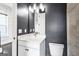 Bathroom features a dark accent wall and light grey tiled shower next to a white vanity and toilet at 1045 Kirkland Cir, Smyrna, GA 30080