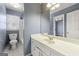 Bathroom featuring a white vanity, large mirror, and a shower-tub combo with natural light at 2840 Riverfront Dr, Snellville, GA 30039