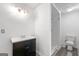 A full bathroom with a black vanity, white countertops, new lighting, toilet, and shower stall at 2840 Riverfront Dr, Snellville, GA 30039