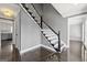 Bright foyer featuring hardwood floors, staircase with black accents, and views into the kitchen and living areas at 2840 Riverfront Dr, Snellville, GA 30039