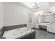 Luxurious main bathroom with a jetted tub, vanity with double sinks, and a modern lighting fixture at 2840 Riverfront Dr, Snellville, GA 30039
