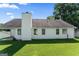 Back of a white-sided home with large windows and a chimney against a sprawling green lawn at 217 Crystal Ct, Hampton, GA 30228