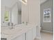 Bathroom featuring a double sink vanity with a large mirror, and a window for natural light at 217 Crystal Ct, Hampton, GA 30228