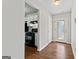 Hallway featuring hardwood floors leading to the kitchen with black appliances and the front door with decorative glass at 217 Crystal Ct, Hampton, GA 30228
