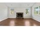 Spacious living room with hardwood floors, a stone fireplace, two windows, and neutral paint at 217 Crystal Ct, Hampton, GA 30228