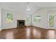 Living room with high ceilings, hardwood flooring, stone fireplace, ceiling fan, and a door to the outside at 217 Crystal Ct, Hampton, GA 30228