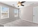 Carpeted bedroom with ceiling fan, lots of natural light, and neutral colored walls at 821 Hood Rd, Fayetteville, GA 30214