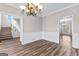 Formal dining area with wood-look floors, wainscoting, and stylish chandelier lighting at 821 Hood Rd, Fayetteville, GA 30214
