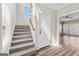 Carpeted staircase leads to a living space with large windows and hardwood floors at 821 Hood Rd, Fayetteville, GA 30214